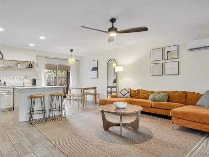 a living room with furniture and a view of kitchen