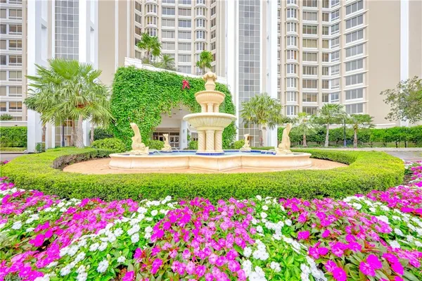 a front view of multi story residential apartment building with yard and swimming pool
