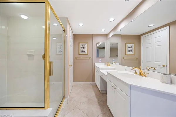 a spacious bathroom with a double vanity sink a mirror and a shower