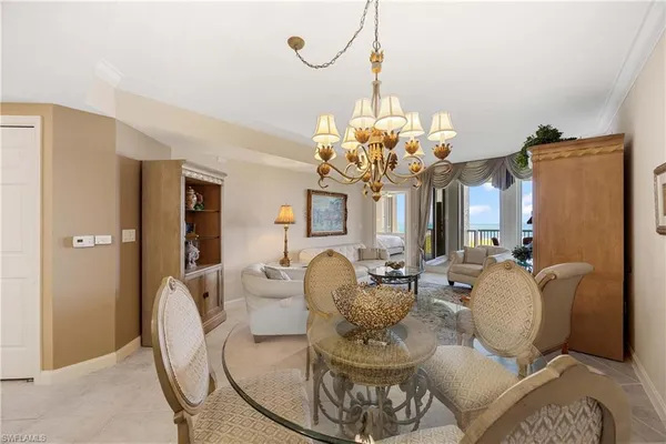 a dining room with furniture a chandelier and kitchen view