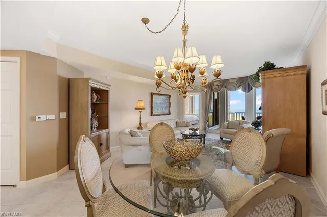 a dining room with furniture a chandelier and kitchen view