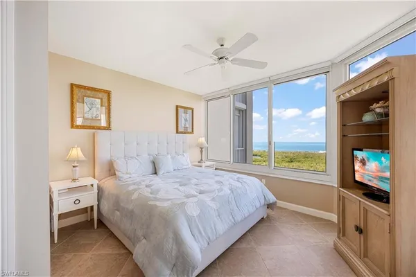 a bedroom with a bed and a large window