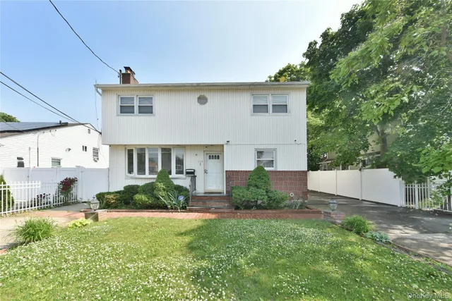 a view of a house with backyard and a sitting area