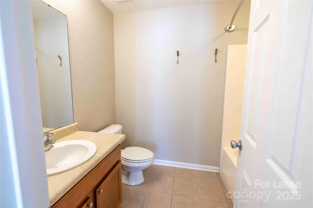 a bathroom with a granite countertop toilet and a sink