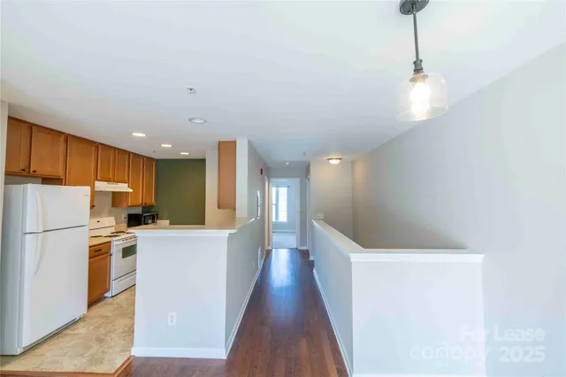 a view of a kitchen with a sink wooden floor and a refrigerator