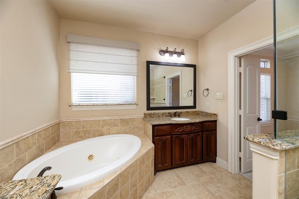 7914 Bishop Road Plano, TX 75024 - Photo 19 of 33 a bathroom with a tub sink and mirror