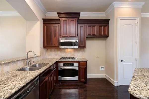 a view of an empty room with wooden floor fireplace and a window