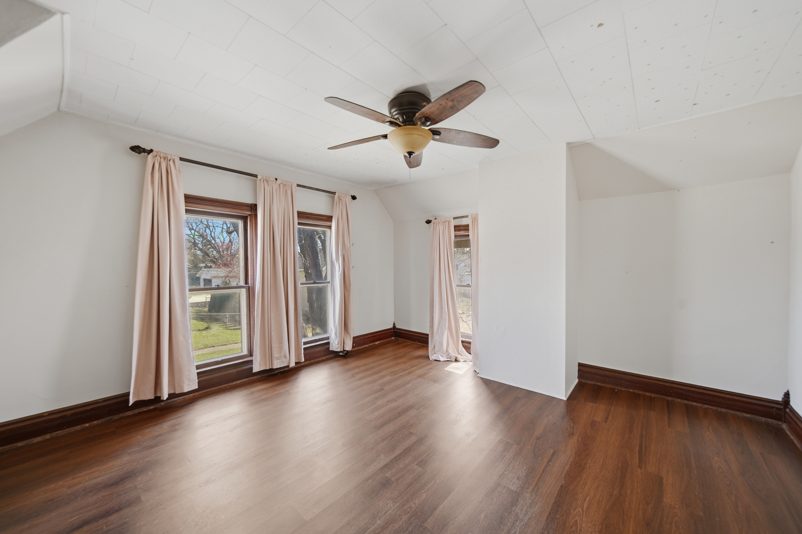 304 West Chamberlin Street Dixon, IL 61021 - Photo 25 of 28 an empty room with wooden floor ceiling fan and windows