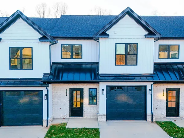 a front view of a house with yard and parking
