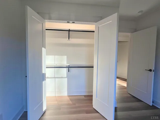 a view of kitchen with white cabinets and a window