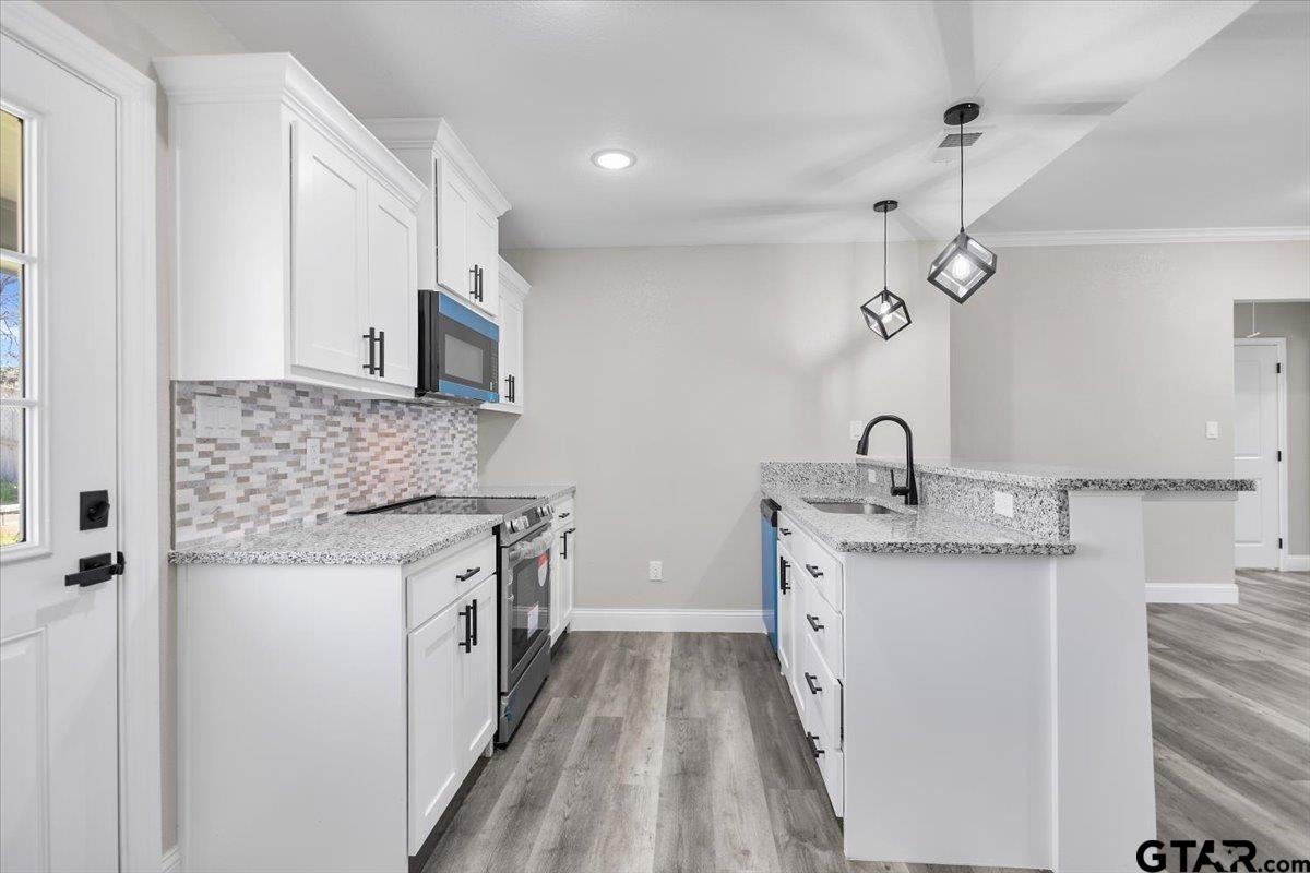 1607 North Ross Avenue Tyler, TX 75702 - Photo 11 of 39 a kitchen with stainless steel appliances granite countertop a sink stove and cabinets