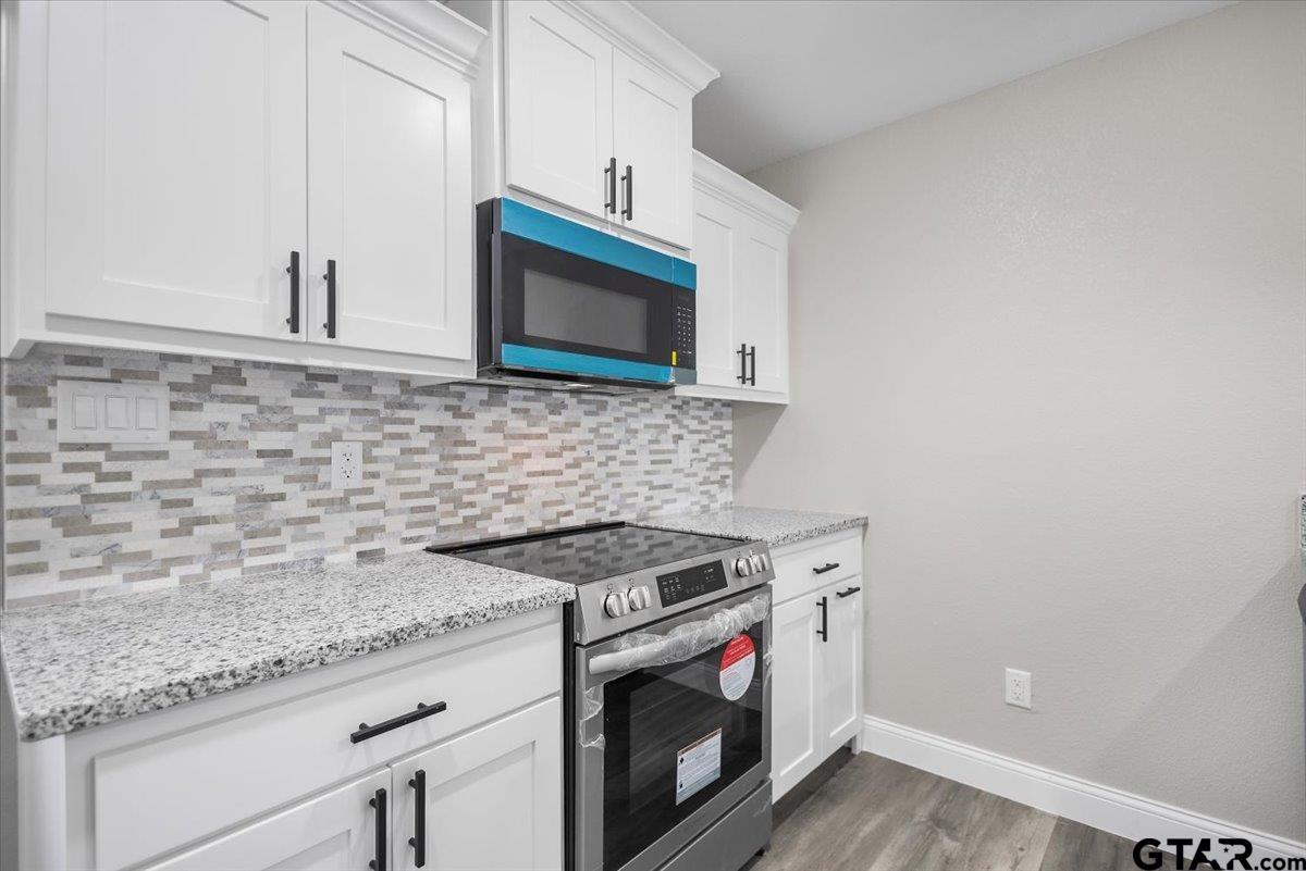 1607 North Ross Avenue Tyler, TX 75702 - Photo 12 of 39 a kitchen with granite countertop a stove sink and microwave