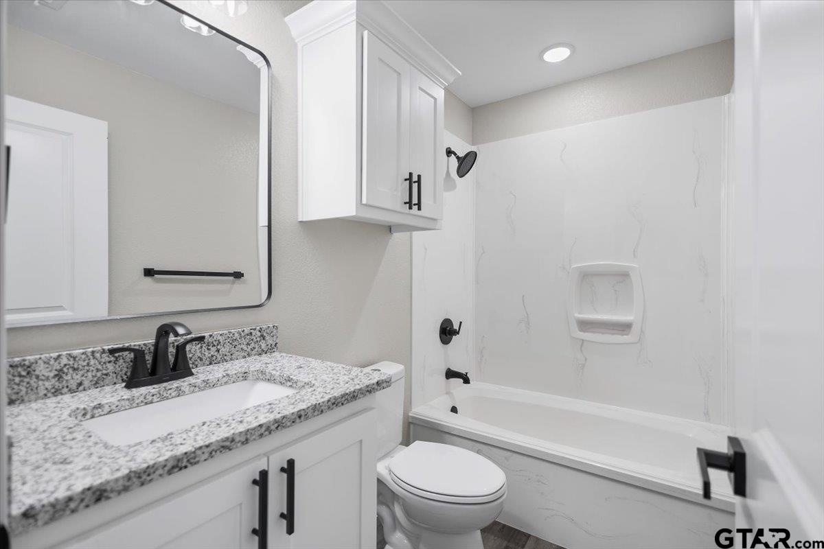 1607 North Ross Avenue Tyler, TX 75702 - Photo 16 of 39 a bathroom with a granite countertop sink toilet and shower
