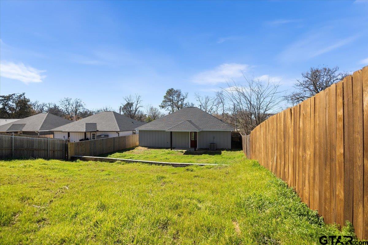 1607 North Ross Avenue Tyler, TX 75702 - Photo 30 of 39 a white house with a yard and wooden fence