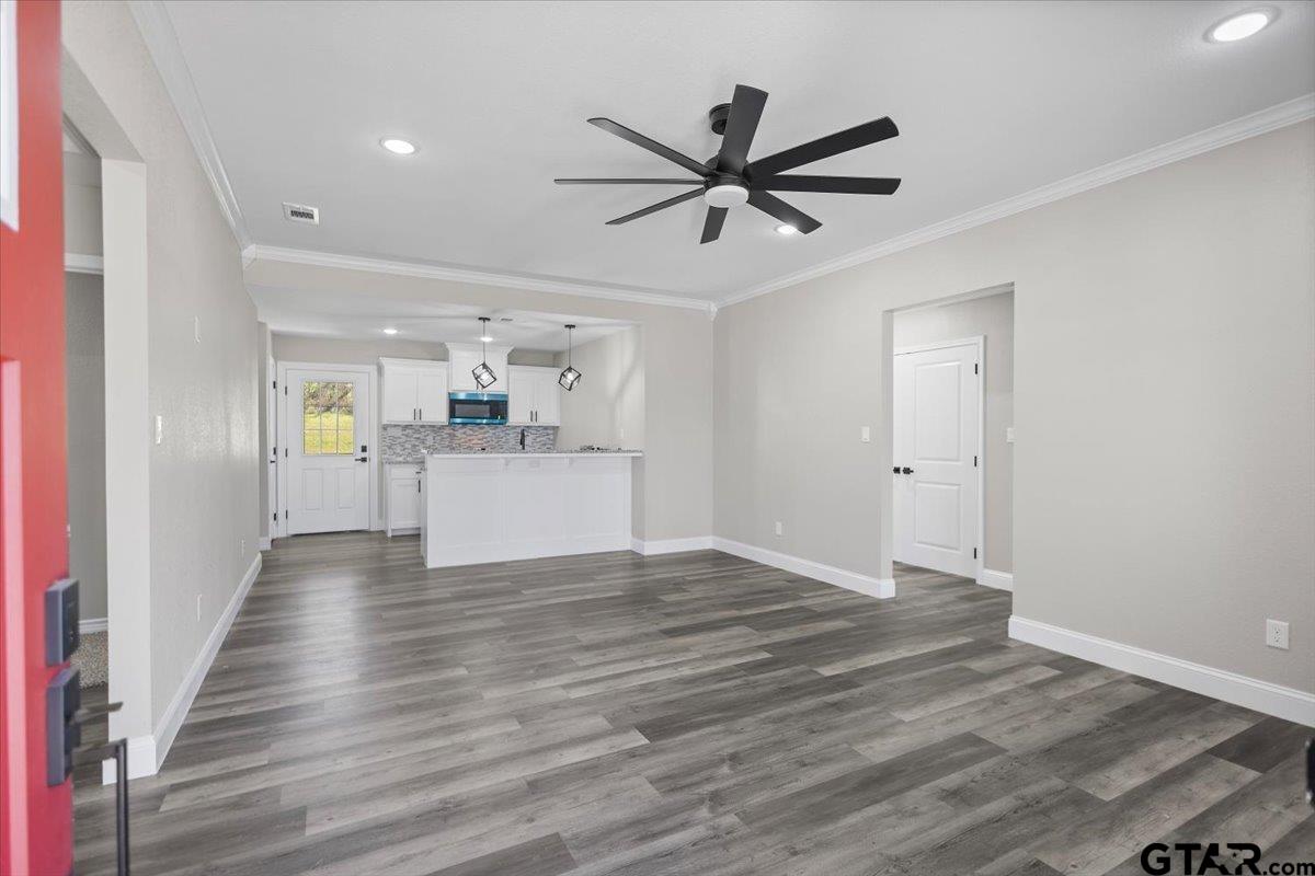 1607 North Ross Avenue Tyler, TX 75702 - Photo 4 of 39 a view of a kitchen with wooden floor and a ceiling fan