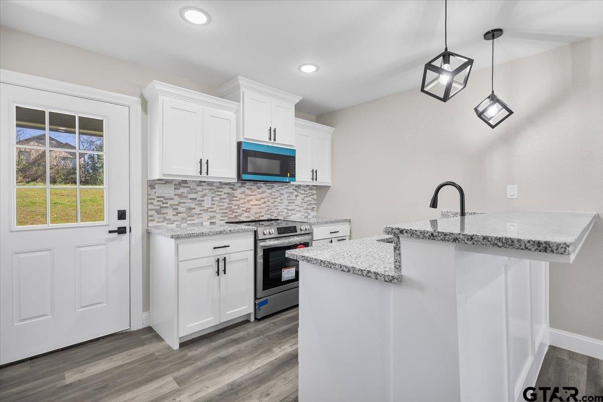 1607 North Ross Avenue Tyler, TX 75702 - Photo 9 of 39 a kitchen with stainless steel appliances granite countertop a stove a sink and a microwave