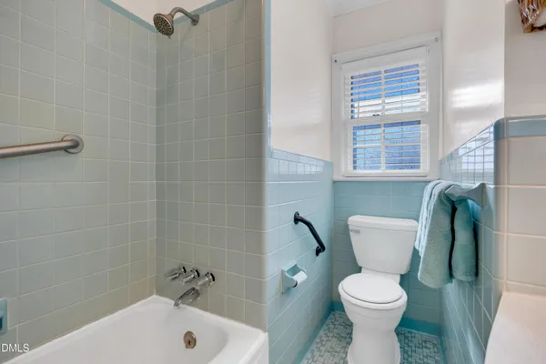 a white toilet sitting next to a bath tub