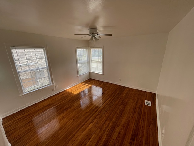 2104 Enfield Road, Unit B Austin, TX 78703 - Photo 8 of 15 an empty room with wooden floor fan and windows