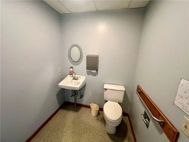 a bathroom with a toilet a sink and mirror