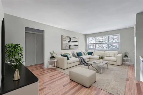a living room with furniture potted plant and a window
