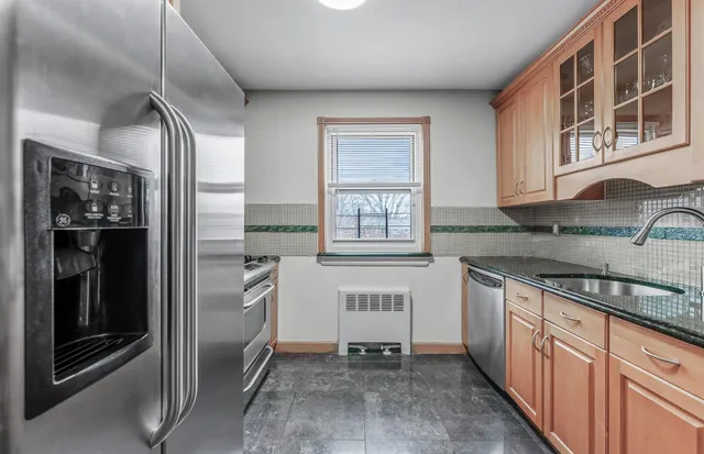 a kitchen with stainless steel appliances granite countertop a refrigerator and a sink