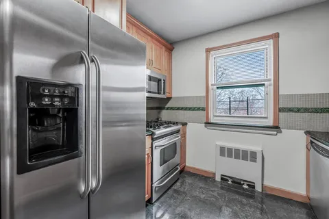 a kitchen with stainless steel appliances granite countertop a refrigerator and a sink