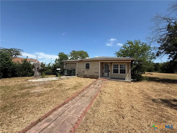 a front view of a house with a yard and trees