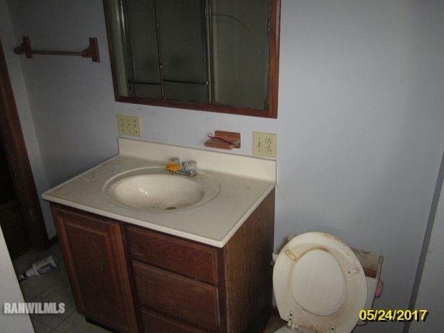 415 Bowen Street Savanna, IL 61074 - Photo 12 of 19 a bathroom with a sink a toilet and a mirror