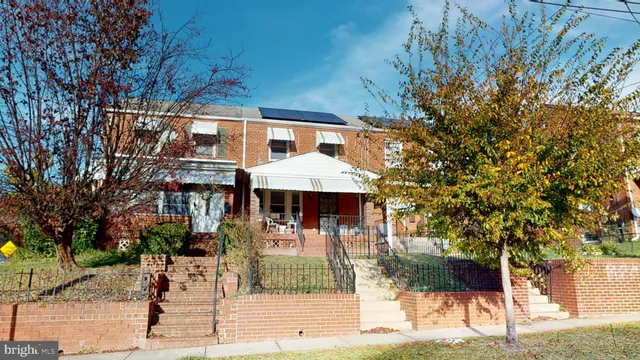 a front view of a house with a tree