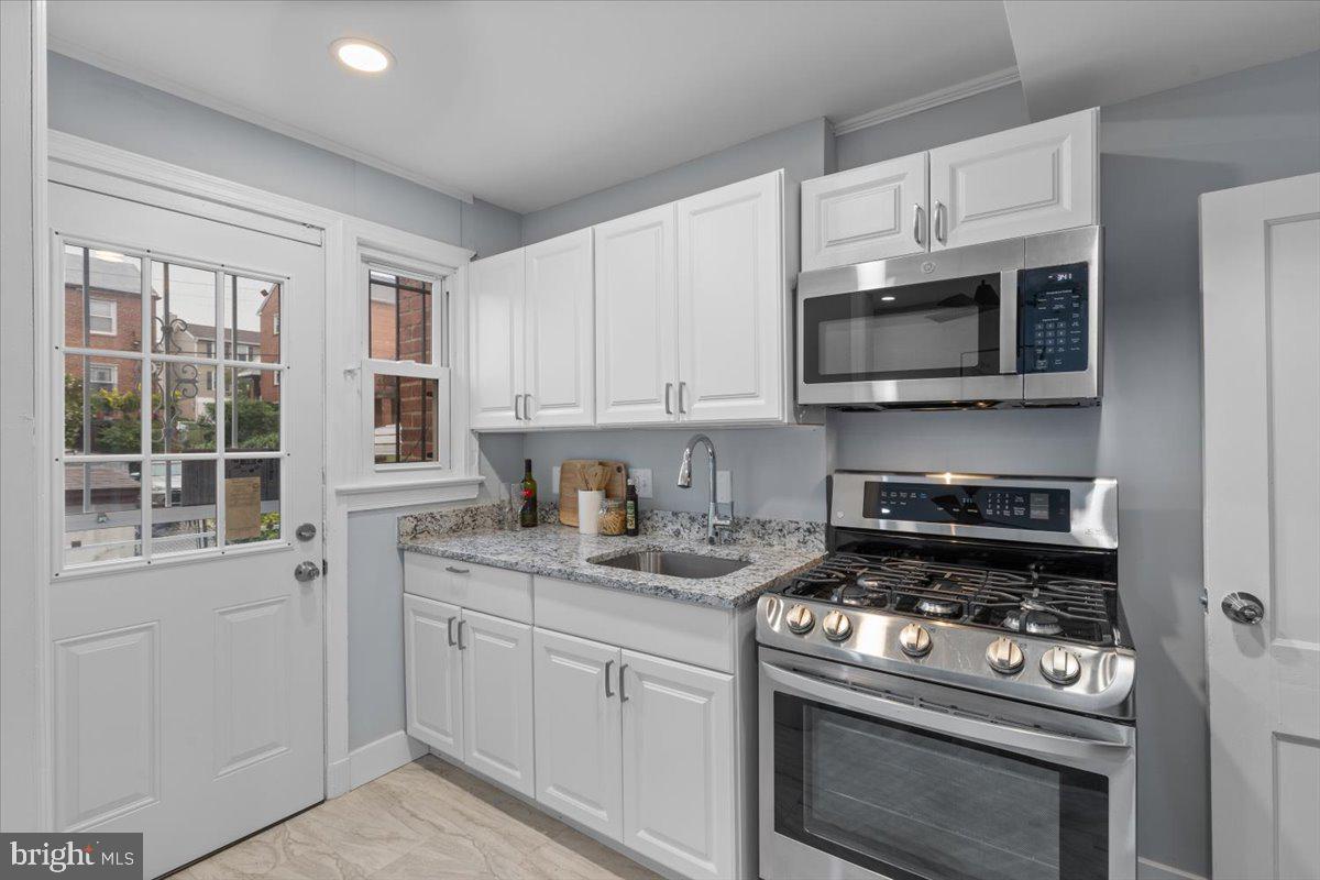 2202 U Place Southeast Washington, DC 20020 - Photo 9 of 21 a kitchen with stainless steel appliances granite countertop a stove microwave and sink