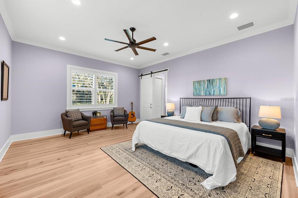 1044 Riverside Ridge Road Tarpon Springs, FL 34688 - Photo 23 of 77 a spacious bedroom with a bed a couch and a window