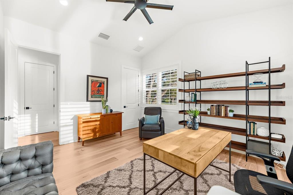 1044 Riverside Ridge Road Tarpon Springs, FL 34688 - Photo 43 of 77 a living room with furniture a rug and a book shelf