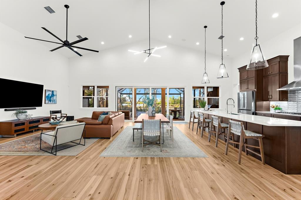 1044 Riverside Ridge Road Tarpon Springs, FL 34688 - Photo 5 of 77 a living room with furniture a flat screen tv and kitchen view
