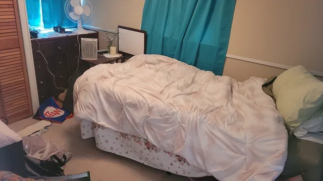 a bedroom with a bed and a wooden floor