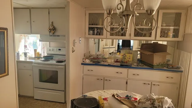 a kitchen with white cabinets and sink