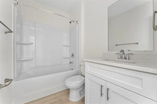 a bathroom with a granite countertop toilet a sink and a bathtub