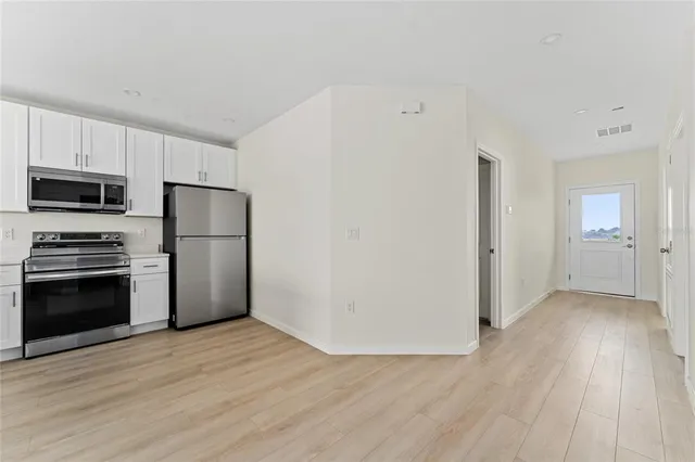 a kitchen with a refrigerator and a stove top oven
