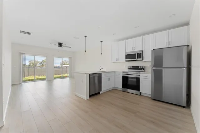 a kitchen with a refrigerator and a stove top oven