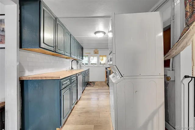 a kitchen with granite countertop a sink stainless steel appliances a refrigerator and cabinets