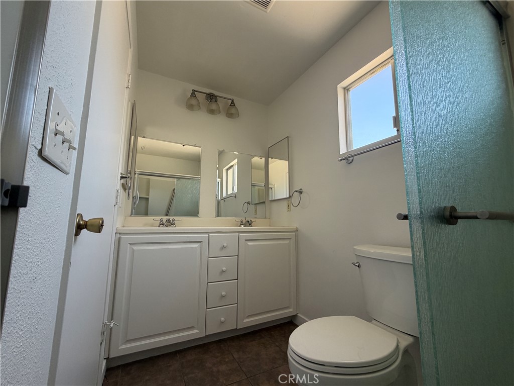 14538 Springvale Street Poway, CA 92064 - Photo 36 of 47 a bathroom with a toilet a sink a mirror a vanity and shower