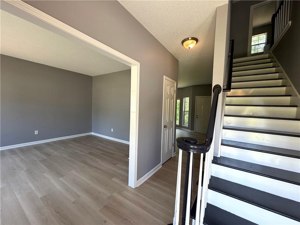 2205 Springer Walk Lawrenceville, GA 30043 - Photo 3 of 26 a view of a hallway with wooden floor and staircase