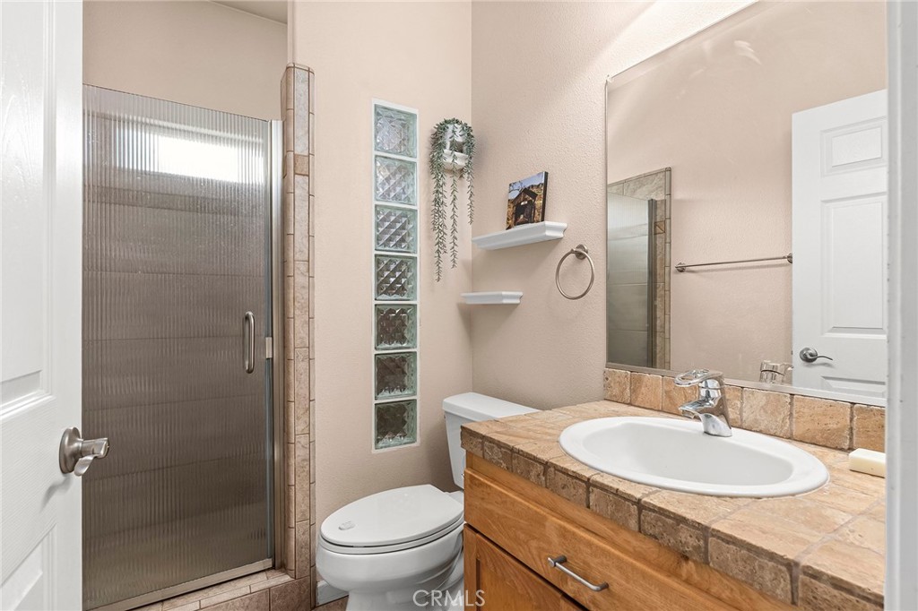 2262 Honey Run Road Chico, CA 95928 - Photo 27 of 74 a bathroom with a granite countertop sink toilet and shower