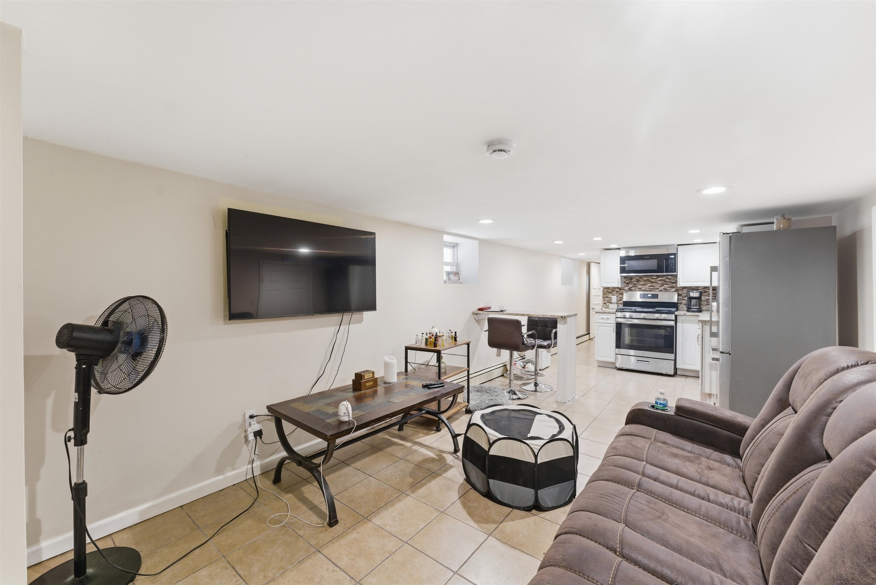 921 Paterson Plank Road North Bergen, NJ 07047 - Photo 20 of 50 a living room with furniture a flat screen tv and kitchen view