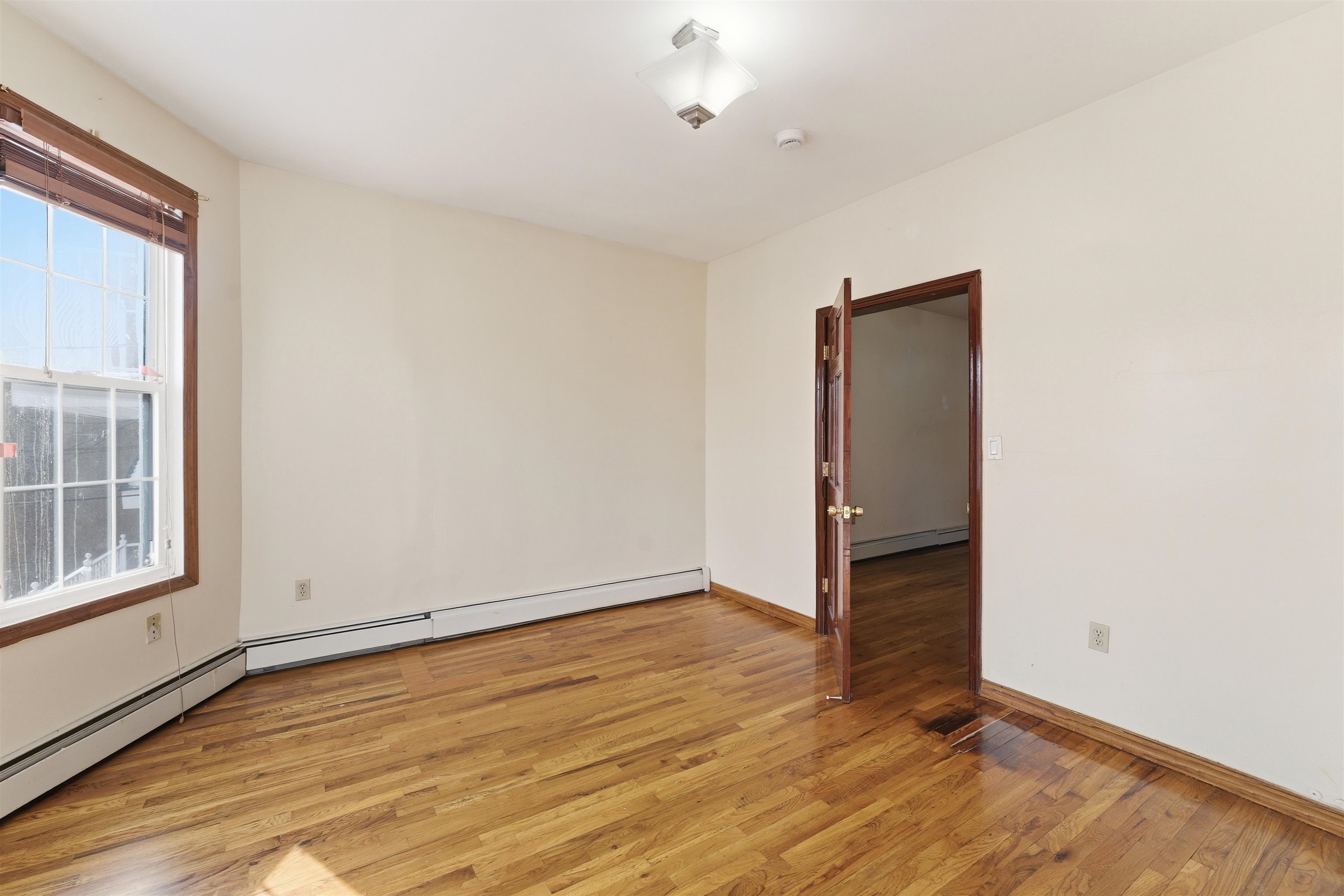 921 Paterson Plank Road North Bergen, NJ 07047 - Photo 41 of 50 an empty room with wooden floor and windows