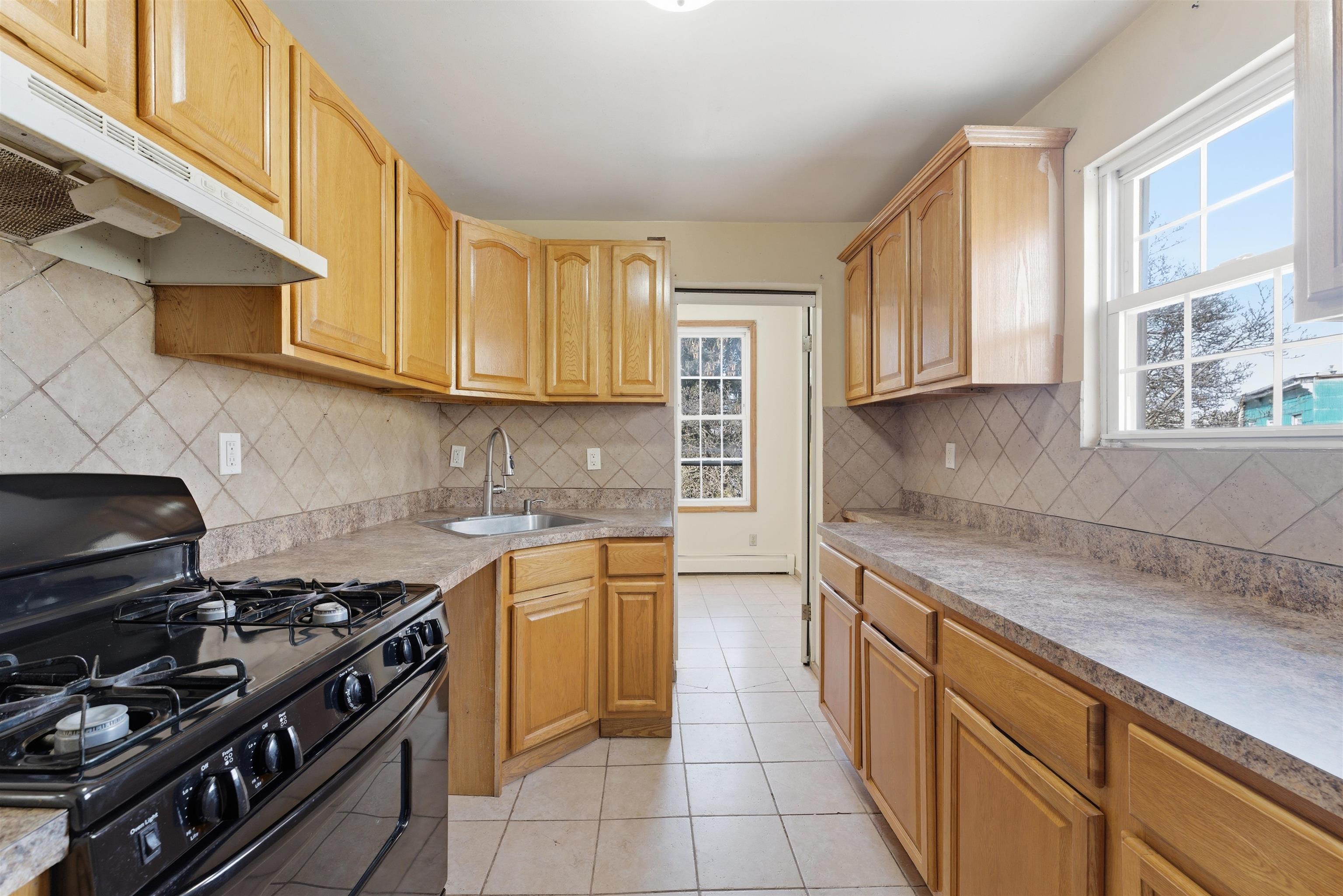 921 Paterson Plank Road North Bergen, NJ 07047 - Photo 6 of 50 a kitchen with stainless steel appliances granite countertop a stove and a sink