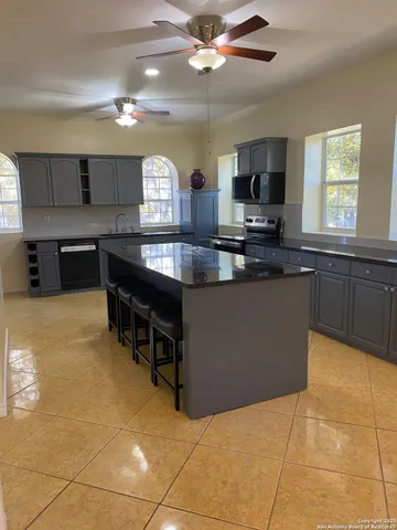 a kitchen with stainless steel appliances kitchen island granite countertop a sink counter space and cabinets