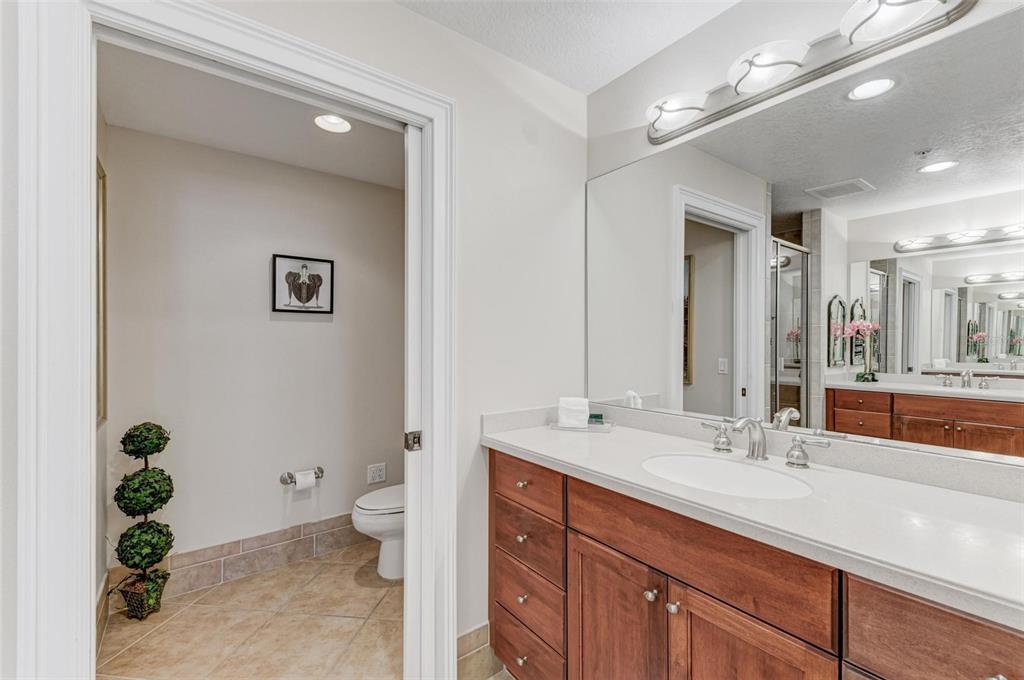 611 Riviera Dunes Way, Unit 304 Palmetto, FL 34221 - Photo 19 of 30 a bathroom with a double vanity sink toilet and a mirror