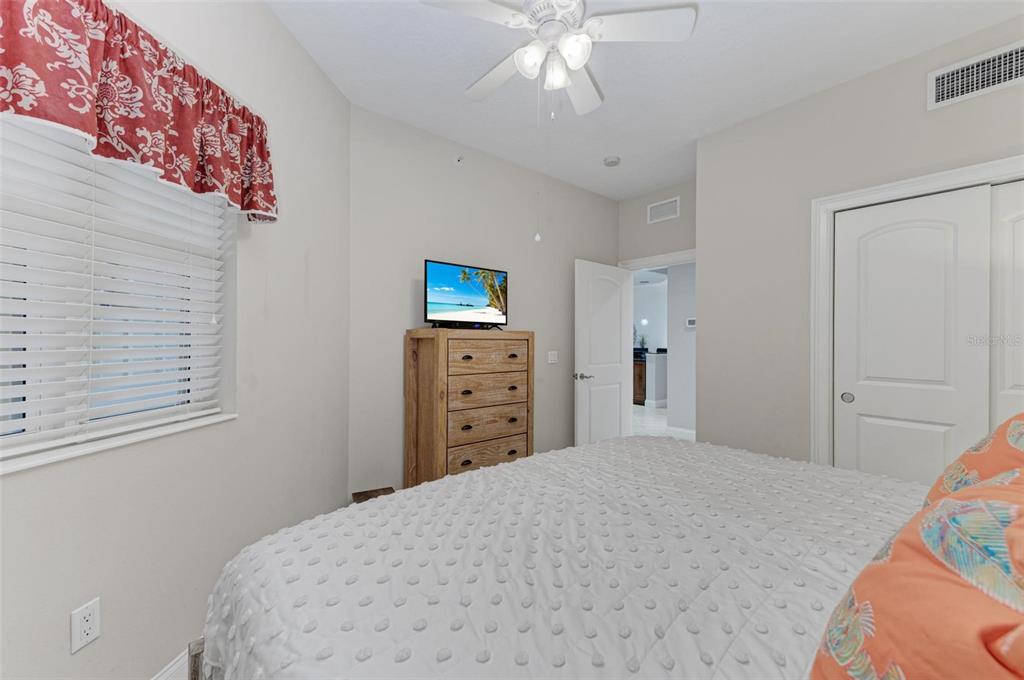 611 Riviera Dunes Way, Unit 304 Palmetto, FL 34221 - Photo 21 of 30 a bedroom with a bed and a chandelier