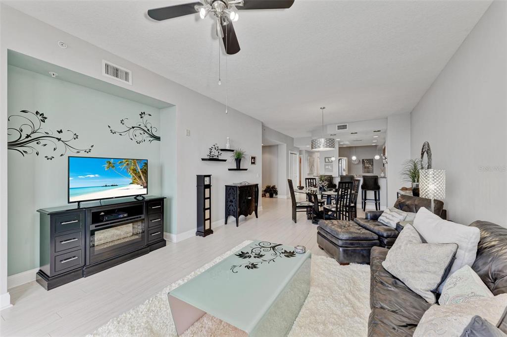 611 Riviera Dunes Way, Unit 304 Palmetto, FL 34221 - Photo 5 of 30 a living room with furniture kitchen view and a flat screen tv