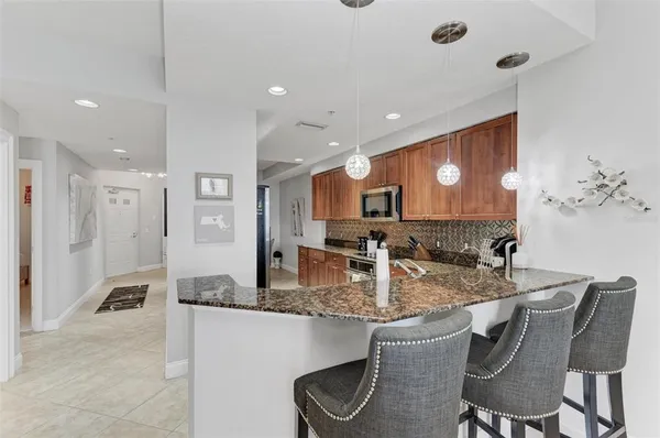 a kitchen with granite countertop kitchen island stainless steel appliances a sink and a counter top space